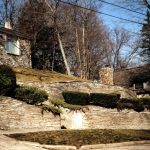 South elevation (rear) of 306 Park Avenue. The wall is constructed of Onaway limestone, laid in the same manner as the house. 306 Park Avenue - Earl Young Mushroom House Tours