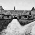 Three miles south of Charlevoix on M-66 is a remnant of the vast 1918 working farm of Albert Loeb of Chicago, vice president and general manager of Sears Roebuck and Company. The estate was modeled on a northern French chateau. Farm equipment to be sold by Sears was tested at Loeb Farms before it was put on the market. The cattle barn shown here had tiled rooms and an exercise courtyard for 200 purebred Holstein-Fresians. Its four stone silos held 1,000 tons of silage each. Loeb Farm