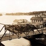 This bridge had not been in place very long when it was discovered that a slight oversight or miscalculation caused a serious problem. On blistering hot days the metal expanded to freeze the bridge shut. The fire department had to dip its pumps into the channel and spray each end to shrink the steel so the bridge could open. Once, the passenger liner Missouri was kept waiting for over an hour in the channel. Her furious captain lay on his horn every few minutes, as if the blast would shake the bridge loose. In the middle appear the twin peaks of Wilbur’s Dock. Bridge Prolems