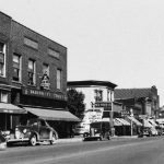 The Bridge Street/Park Avenue corner in the 1930s, looking north. The tall building to the left of the bridge is the Alhambra Hotel. Adams’ Lunch Room and magazine stand occupies the north Park Avenue corner. At far left appears the popular and stylish Polly Kay store for women’s and children’s clothing. The Oddfellows Hall is above it. At the south Park Avenue corner is Dahlquist’s Five & Dime Store before it moved south to the Mason Street corner. Bridge Street in the 1930's
