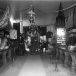 Crane’s dry goods store occupied most of the ground floor of the bank building. A dog sits on the counter at left. Light from the Clinton Street entrance appears at rear left. The Cranes did not reopen after the fire. Crane’s