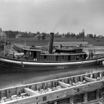 U. S. Government tug General Williams passes through the upper channel past the Charlevoix Resort Association, later the Belvedere Club, around 1890. U. S. Government tug General Williams